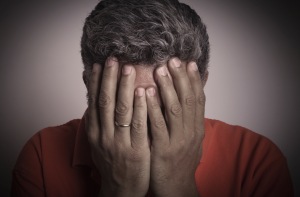 A close up of a person covering their face with their hands, ashamed. Source: Huffington Post