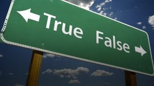 A green freeway sign pointing to "true" in one direction and "false" in the other. Source: Women Vote PA