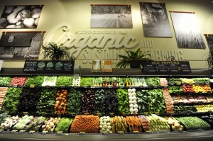 A grocery store display of vegetables under a sign reading "Organic and sustainable farming" 