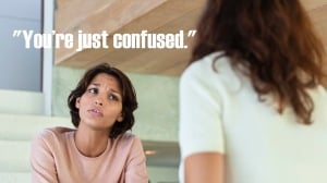 A person sits and frowns at someone facing away from the camera. The words "you're just confused" on the image.