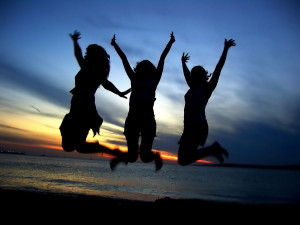 Silhouettes of three people jumping up in the air