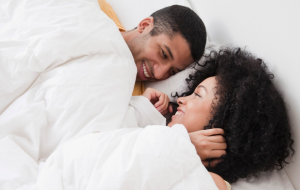 Couple in bed, looking happy