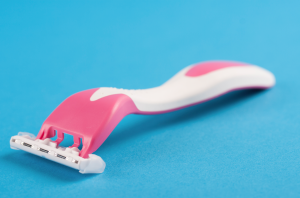 A pink razor against a blue background