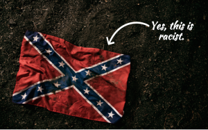 A confederate flag lays on the ground; a white arrow points to it and reads, "Yes, this is racist."
