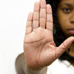 A person holds up one hand, as if to say "Stop"
