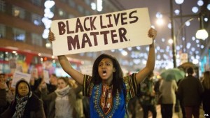 A person is holding up a "Black Lives Matter" sign at a protest