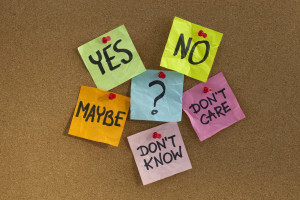 On a cork board is a group of tacked up post-it notes reading "yes," "no," "don't care," "don't know," and "maybe."
