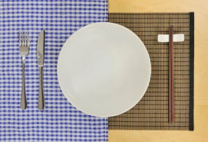 A plate set with a fork, knife, and chopsticks