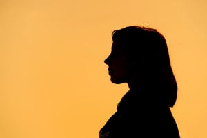 Silhouette of a person against a yellow-orange background