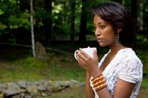 A person outside, drinking a cup of tea