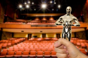 A person holding up an Oscar to an empty auditorium