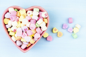 A heart-shaped bowl full of conversation candy hearts