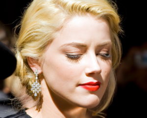The image features a portrait of Amber Heard in formal attire. Source: Wikipedia
