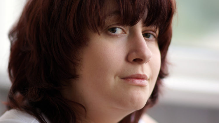 Closeup of a person gazing into the camera with a pensive expression.