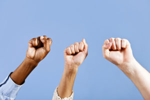 Three clenched fists against a blue background.
