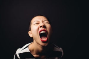 Person with mouth wide open appearing to be screaming