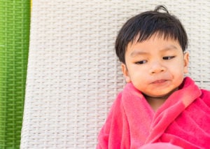 Toddler wrapped in a towel while giving the side eye
