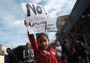 Young person holding a sign that reads " during the Women's March in Los Angeles, California. 