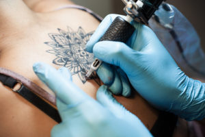 Person getting a tattoo on their upper back