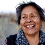 Indigenous person laughing, looking off to the side