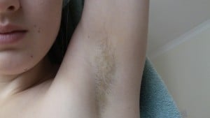 Person with their arm up, revealing underarm hair