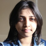 Young person looking toward the camera in a sunny room