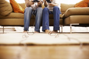Two people sitting on a couch, playing video games