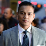 Person looking serious in a three-piece suit on a city street