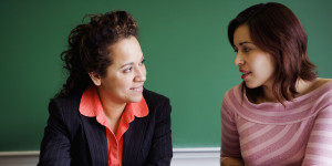 Two people having a conversation in a classroom setting