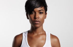 Person staring directly into the camera, wearing a white tank top, set against a white background, looking very intensely