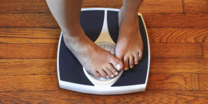 Person with painted toe nails standing on a scape, covering up the number with their feet, embarrassed