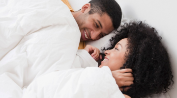 Couple in bed, looking happy