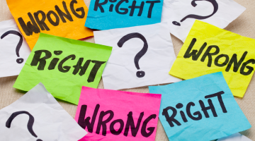 A bunch of Post-It notes lie on a table with question marks and "Right?" and "Wrong?" written on them