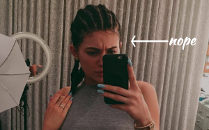 An image of Kylie Jenner taking a selfie with cornrows. An arrow points to her head saying "nope."