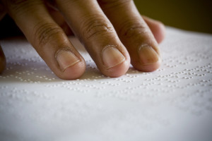 A hand is reading braille