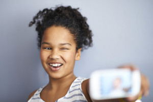 A young person takes a selfie with their phone