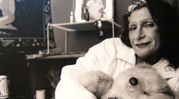 A black-and-white image of Sylvia Rivera, holding onto a teddy bear