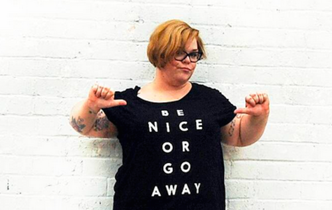 The author, Jes Baker, wearing a black t-shirt that reads "Be Nice Or Go Away"