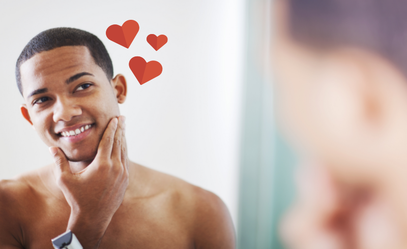 Person looking in a mirror, with hearts around their head, indicating self-love