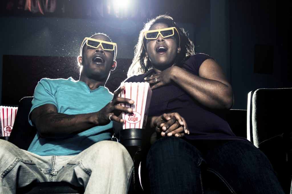 Two people at a movie, scared by what they see on screen