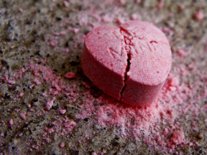 A pink candy heart, reading "Be mine," sits crushed on the fllor