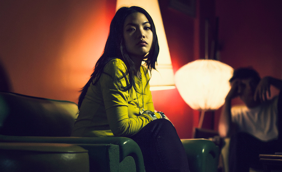 Young person sitting in a dimly lit room