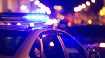 A police car lit up in a city at night