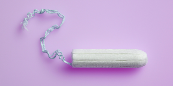 A white tampon agains a light purple background
