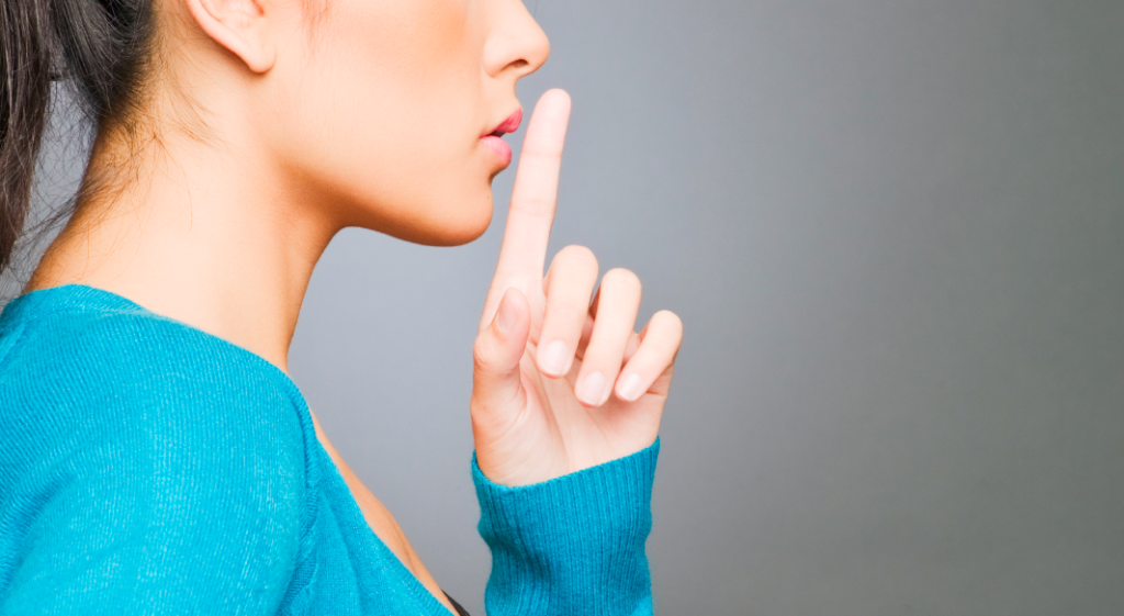 Person holding a finger to their lips, saying "Shh"