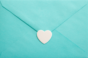 A turquoise envelope sealed with a white heart