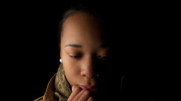 A person in shadows, looking upset