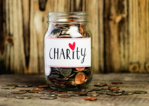 A jar of coins that reads "Charity," with a heart dotting the I.