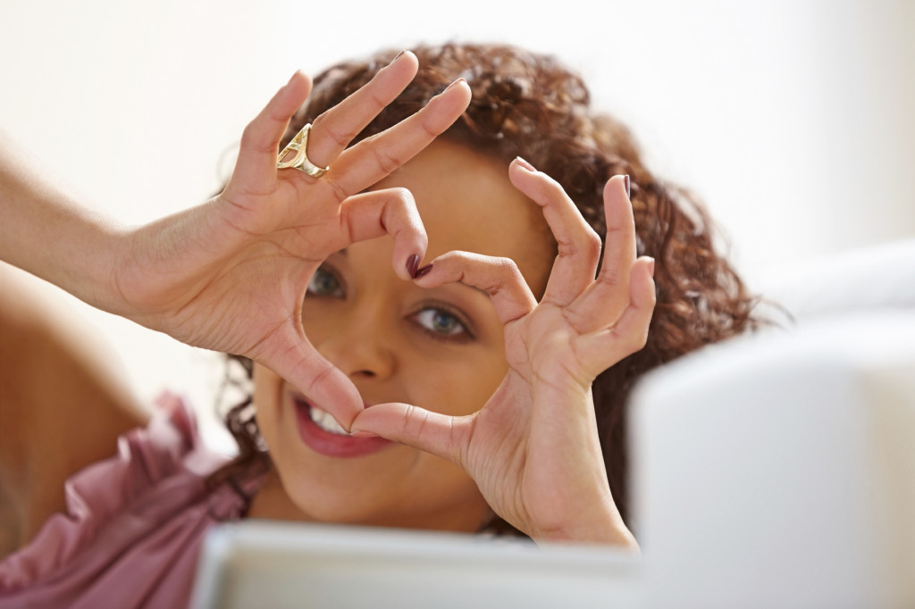 A person making a heart symbol with their hands.