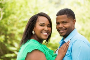 A person of size has their hands on another person's chest. Both individuals are smiling into the camera.